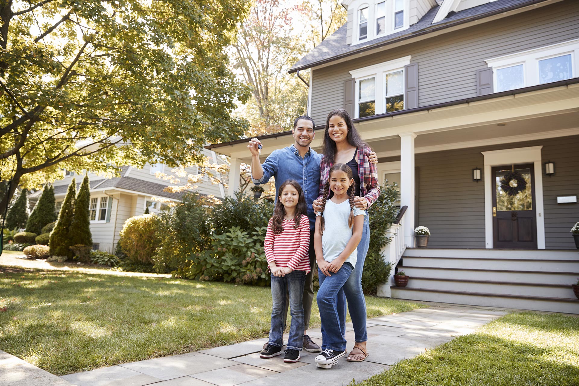Image of family standing outside their new home